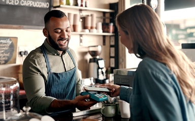 Man handing woman coffee at a cafe