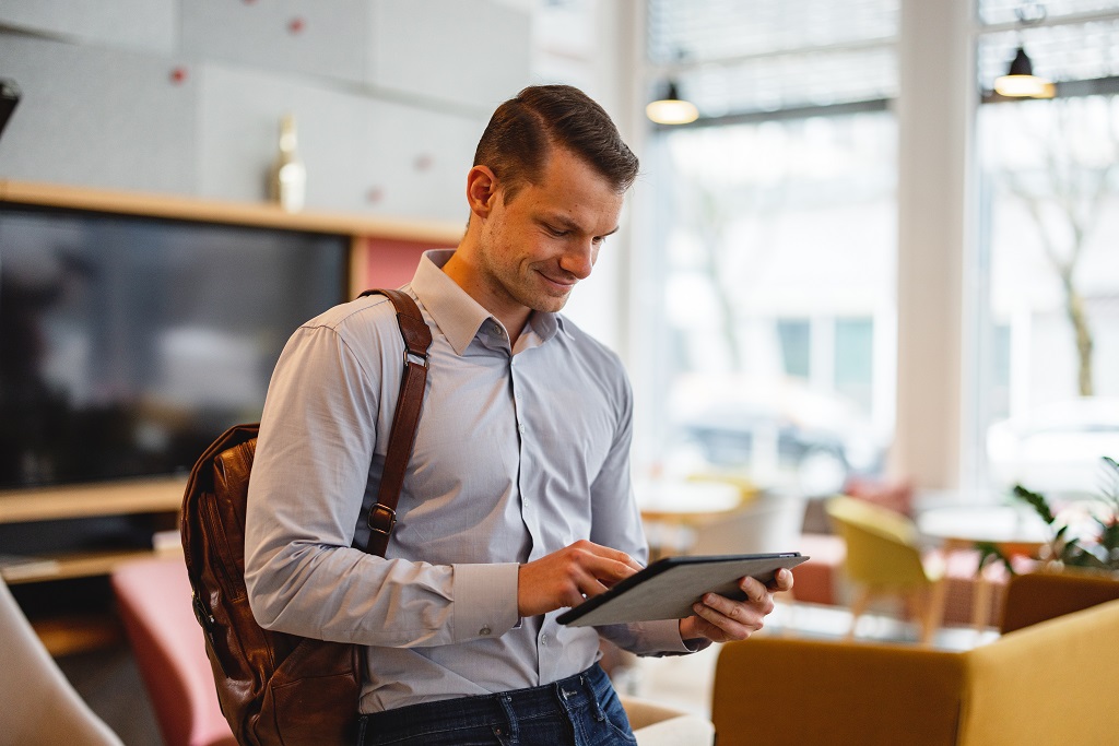 Man-with-backpack-using-tablet