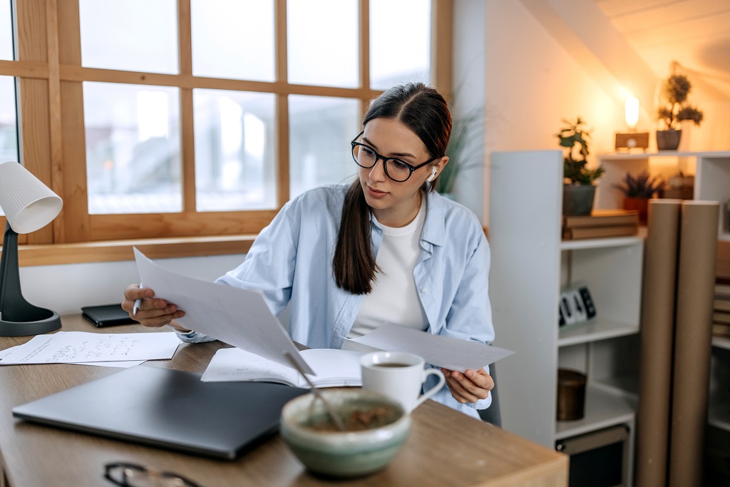 Dark-hair-woman-reading-documents-at-breakfast-table