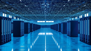 Rows of illuminated server racks in a data centre with a digital network visualisation overhead.