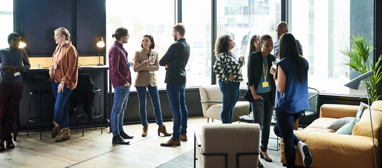 People standing in small groups chatting at work function