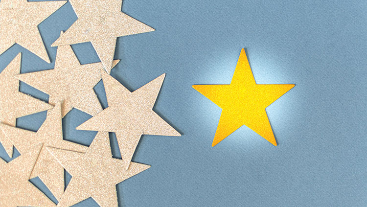 Gold stars with one yellow star in spotlight
