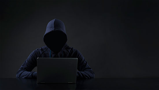 Dark image person hoodie laptop