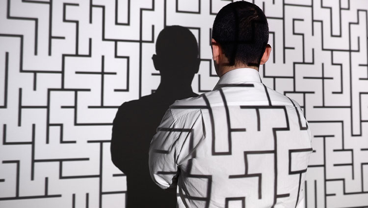 Maze projected on wall business person looking