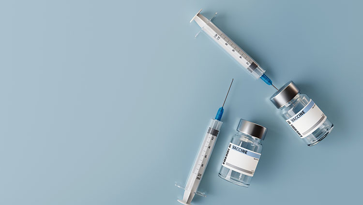 Needles with vaccine bottle on blue background