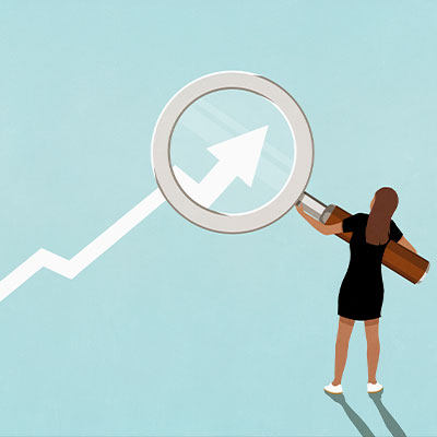 Woman holding magnifying glass over ascending graph arrow on blue background