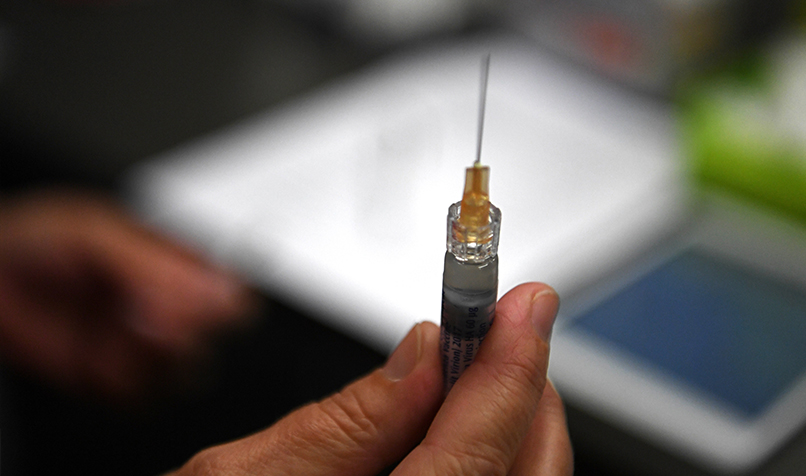 A flu immunisation needle is seen as part of a work-provided Flu vaccination initiative in Rhodes, New South Wales. (AAP Image/Sam Mooy)