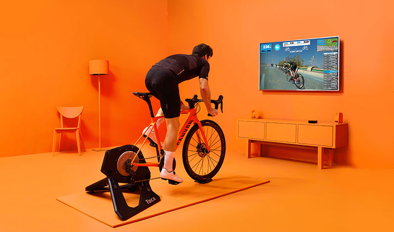 Man riding exercise bike in orange room