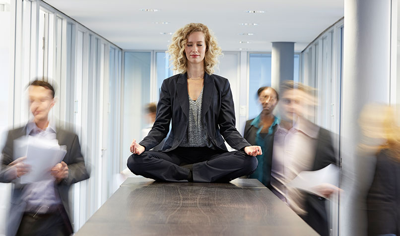 Business women meditating work desk