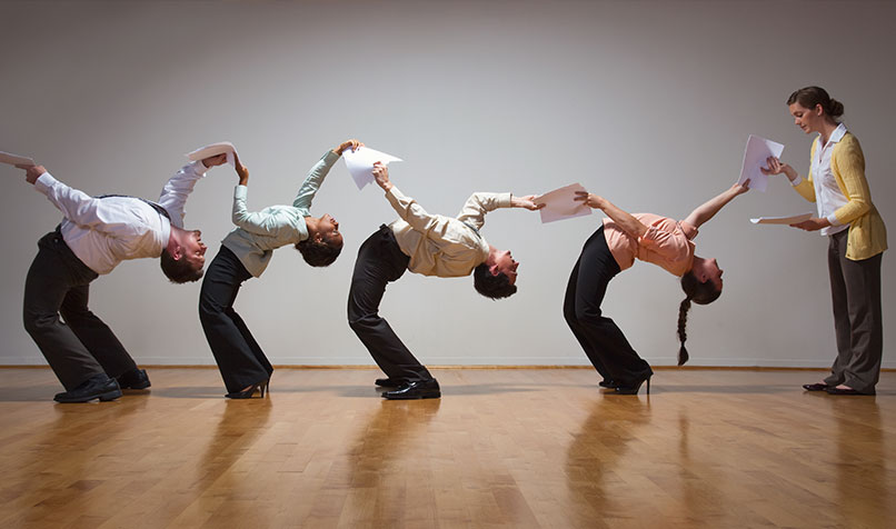 Office workers bending over backwards passing documents