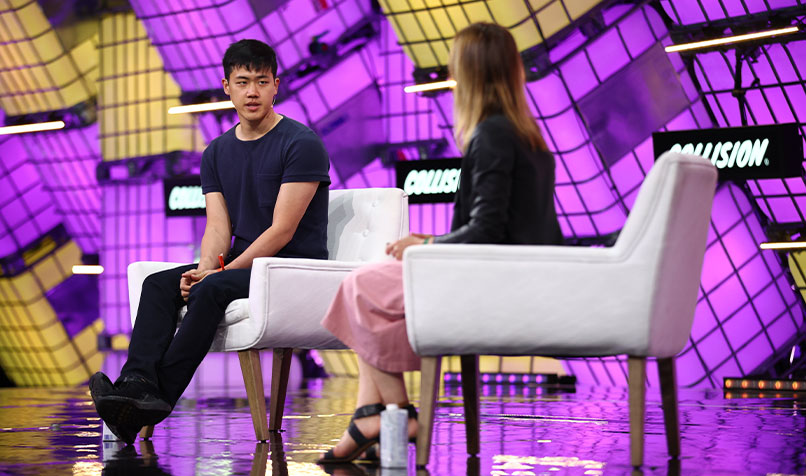 Andy Feng sitting on stage at Collision conference