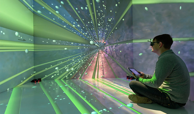 Man sitting down looking at projection on wall