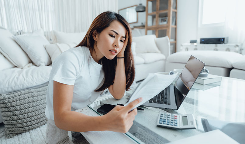 Women sitting lounge room reading document