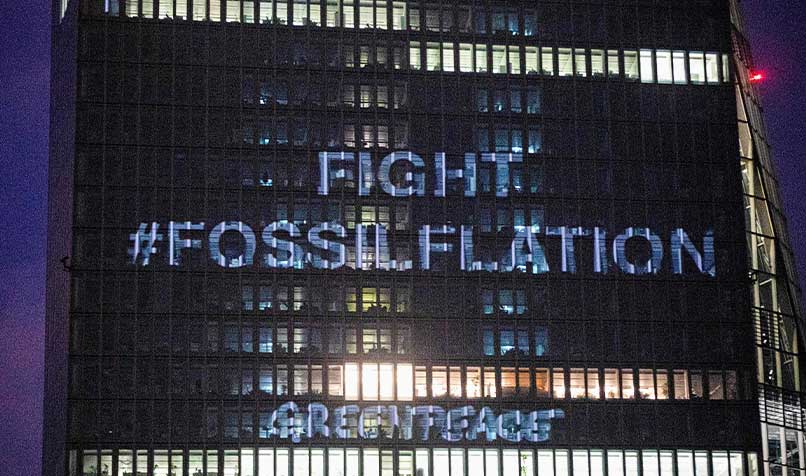 Greenpeace activists project a message on building