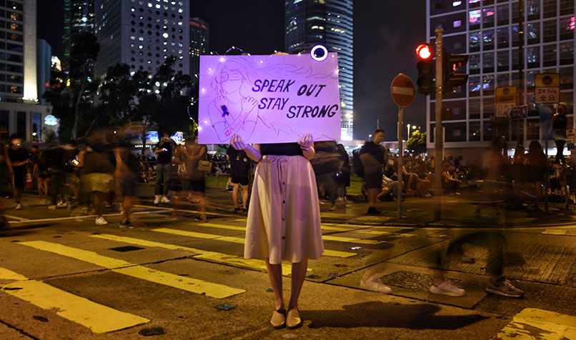 Women holding sign speak out stay strong