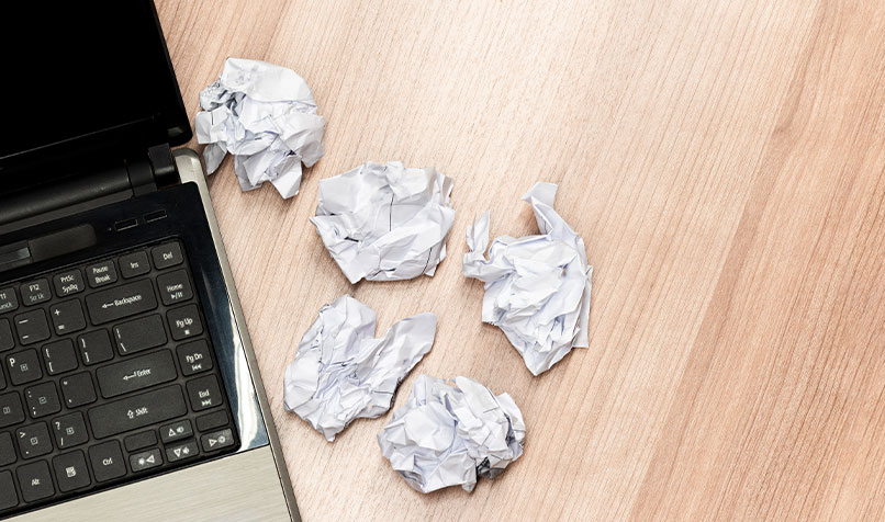 Laptop desk scrunched up paper