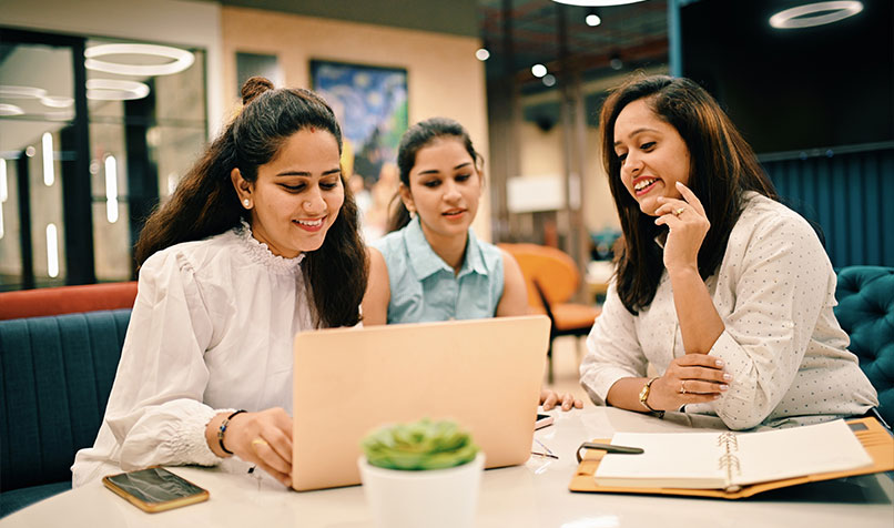 Young Indian business people table laptop