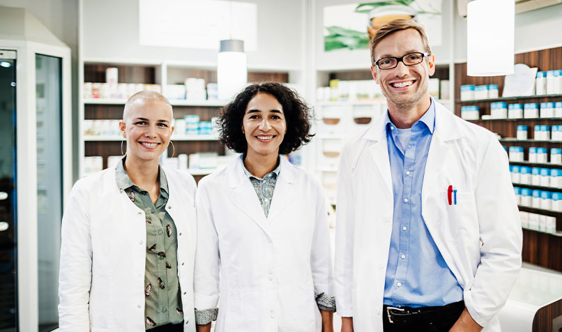 Three people standing in pharmacy
