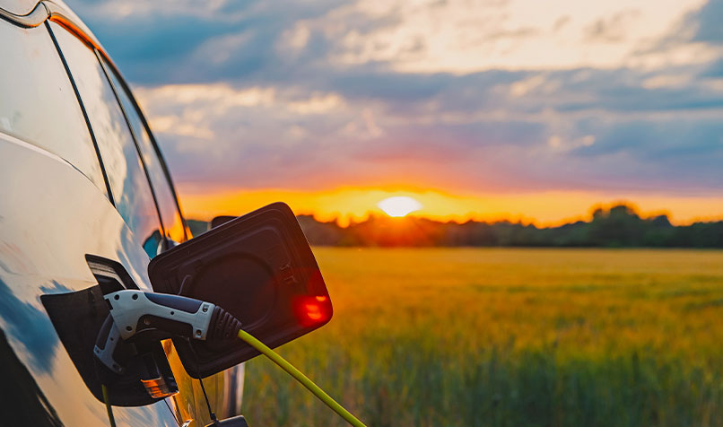 Sunset electric car being charged