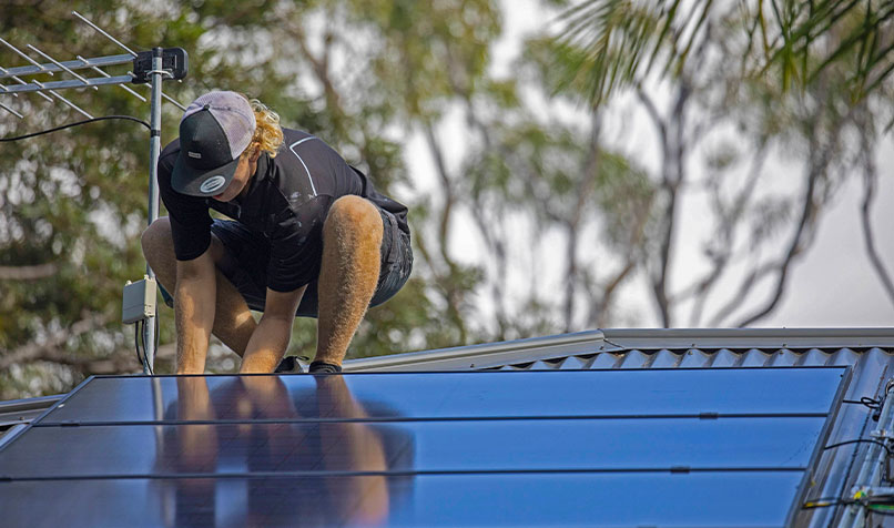 Roof person installing solar panel