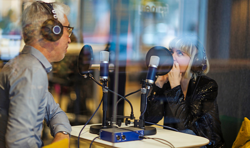 Two people recording podcast