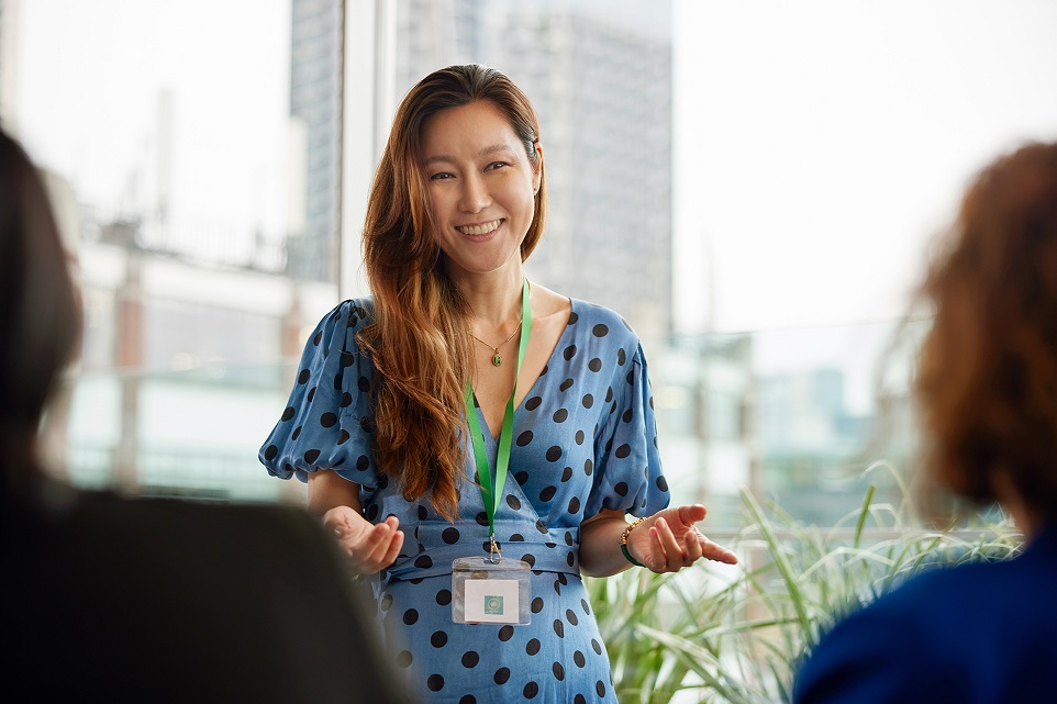 woman with lanyard in discussion with two colleagues