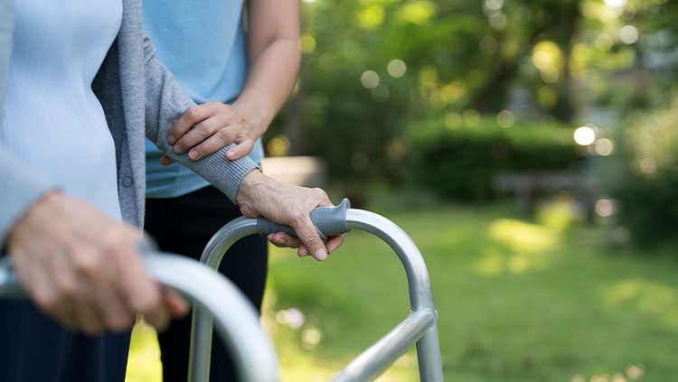 Older person on frame being helped