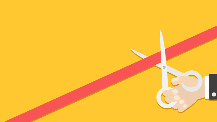 Business person hand with scissors cutting red tape