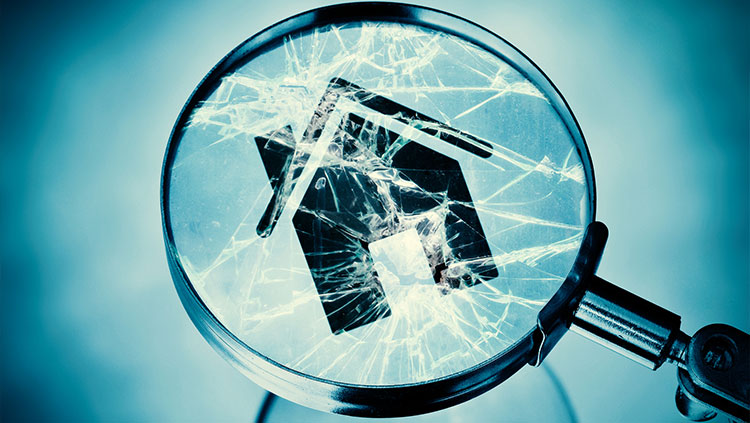 Cracked magnifying glass looking at house