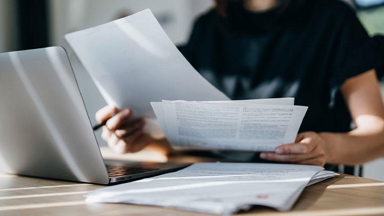 Person holding documents desk