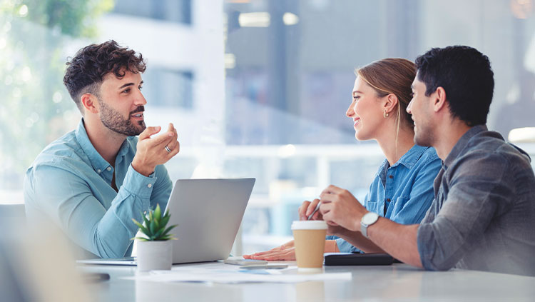 Three people meeting table laptop