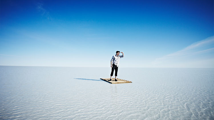 Business man standing raft in water