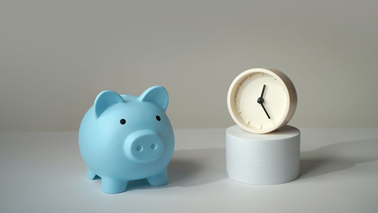 Blue piggy bank next to clock