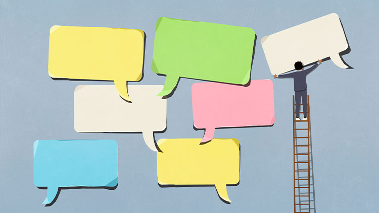Business person on ladder arranging large, multicolored speech bubbles on blue background