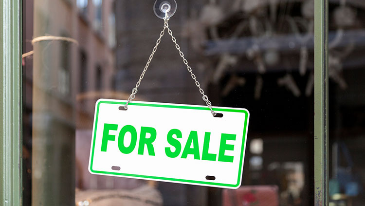 Green for sale sign on business door