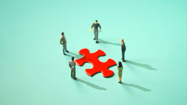 People standing around jigsaw puzzle preview