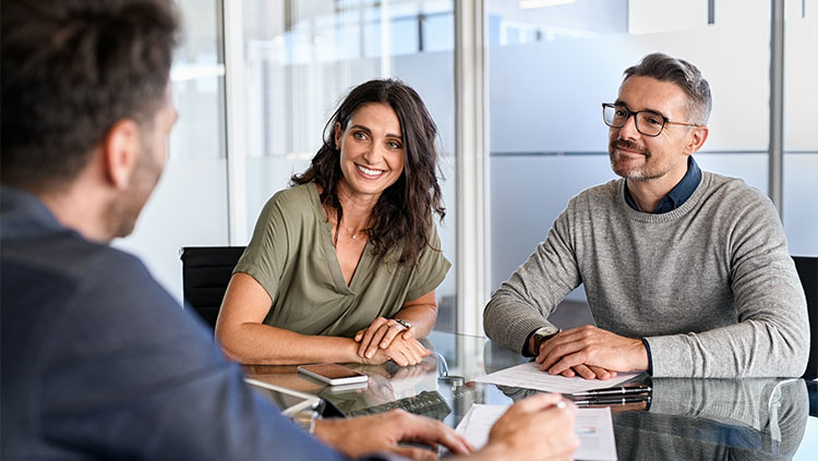 3 people talking around desk meeting