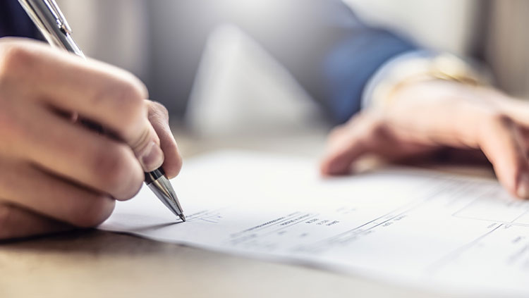 Close up person signing document