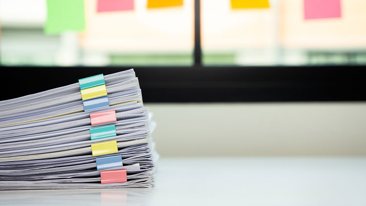 Stack of papers on desk colourful clips