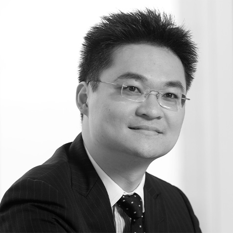 Professional headshot of a person wearing glasses and business attire