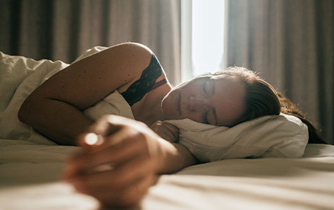 Person sleeping sun coming through curtains