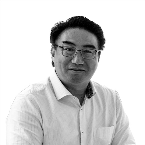 Man with glasses and dark hair wearing white shirt and looking at camera