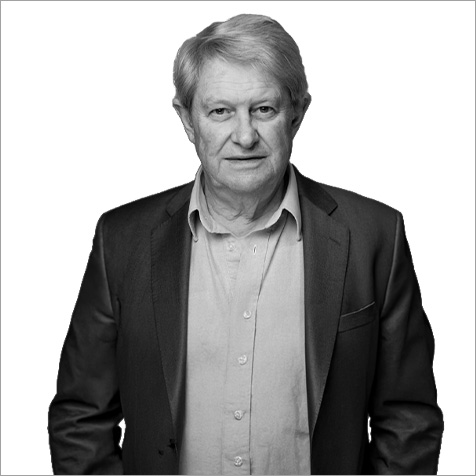 Older man with grey hair in a shirt and suit jacket undone