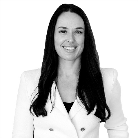 Professional headshot of a person with long dark hair wearing a light-coloured blazer against a plain background.